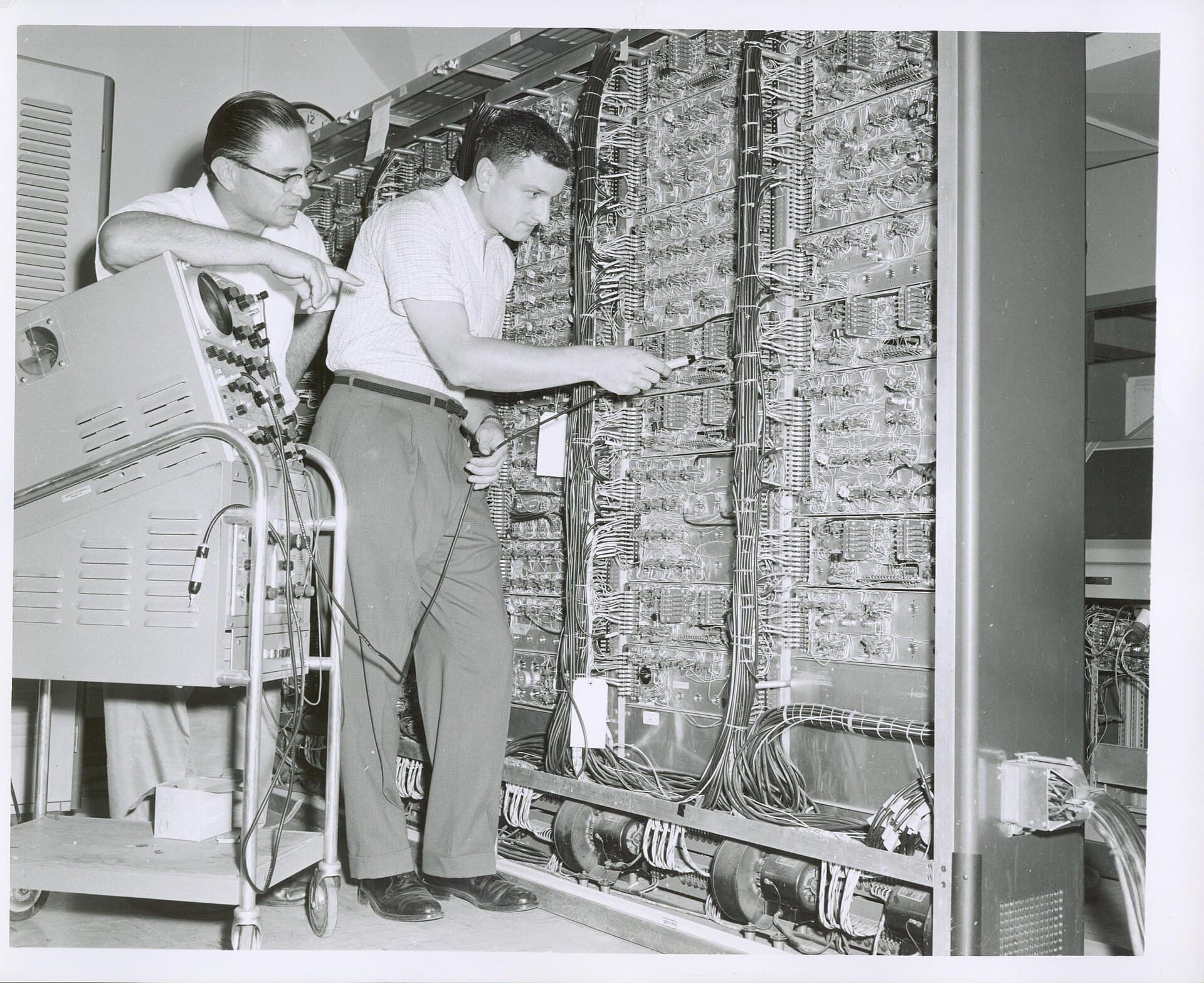 Census Bureau technicians inspecting a computer frame full of wiring