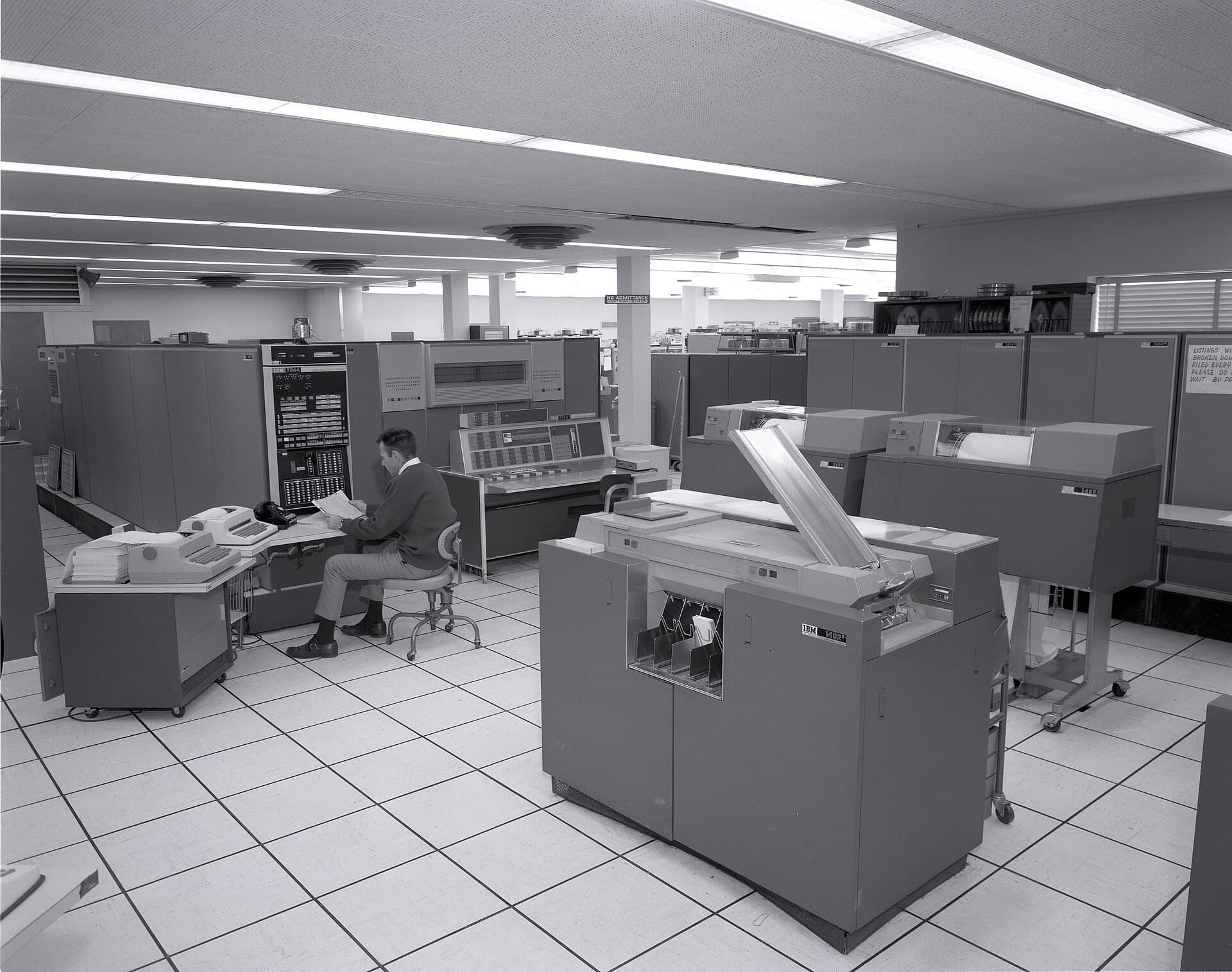 A wide computer room floor lined with cabinets and printers