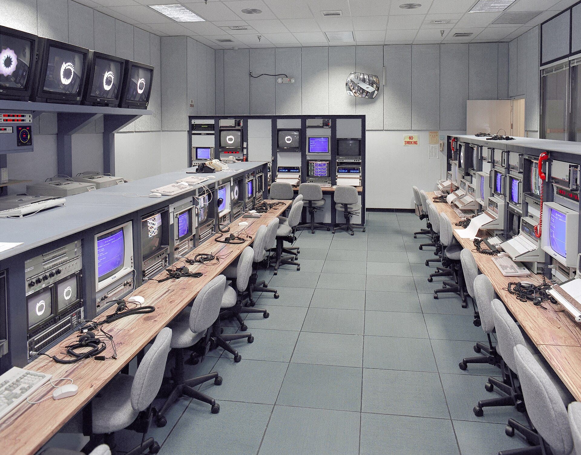 A mission control room lined with consoles
