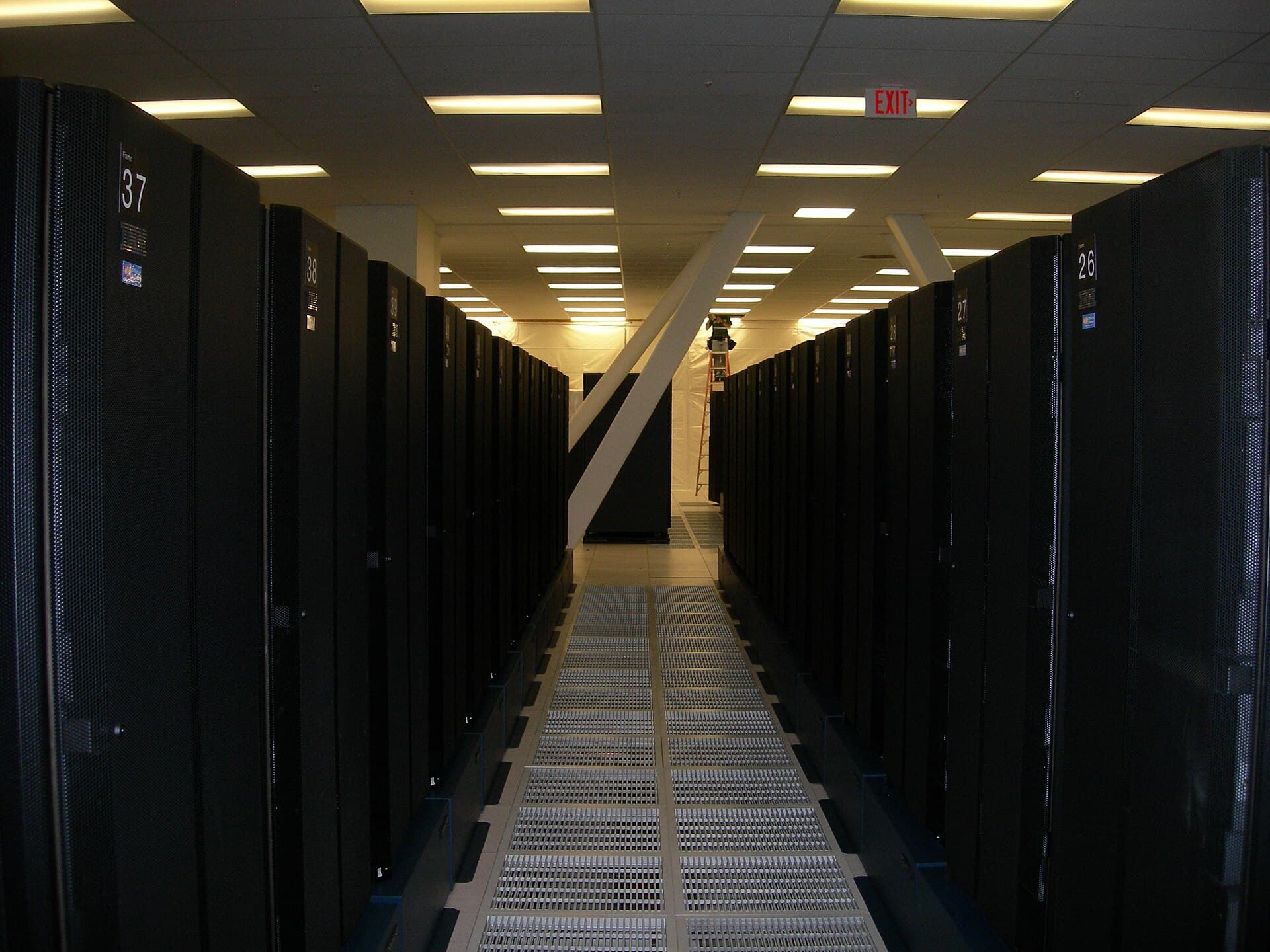 A long aisle between black server racks