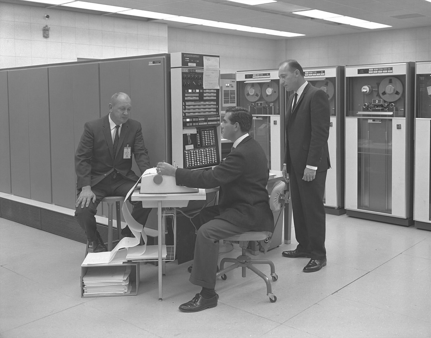 Engineers at an IBM 7094 console with tape drives behind them, 1966
