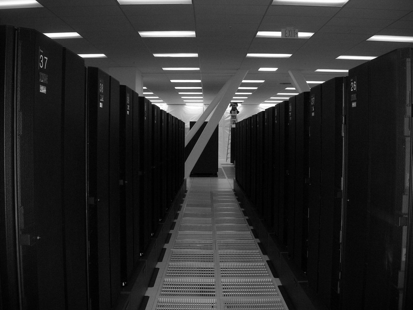 An aisle between rows of black server racks